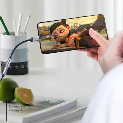 USB-C to 3.5mm audio adapter connected to a phone for video and music