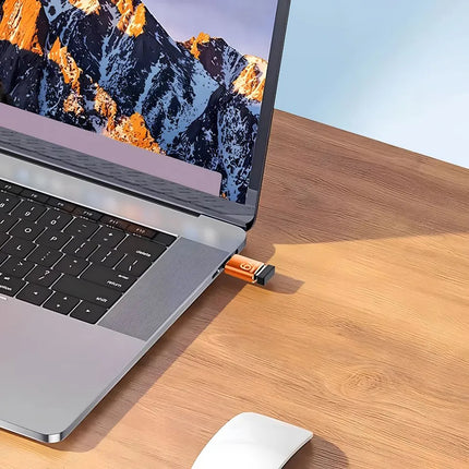 Orange USB-C to USB-A adapter connected to a laptop USB-C port